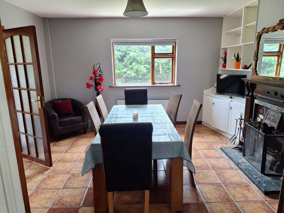 A dining room with a table and chairs at Lilly's Bungalow in Timoleague