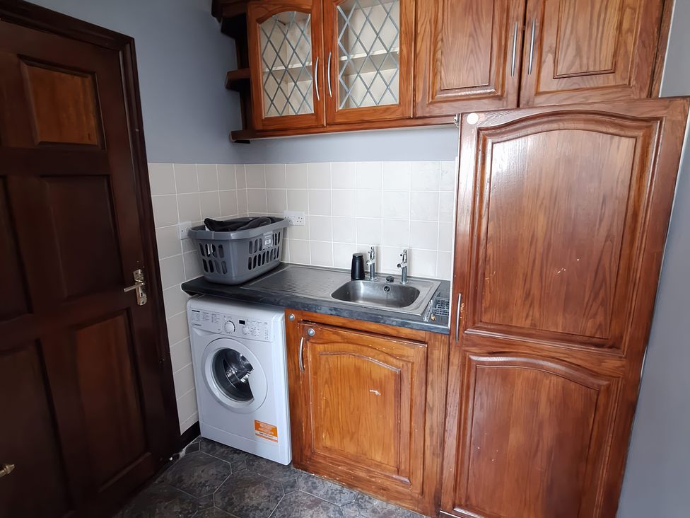 A laundry room with a washing machine and sink at Lilly's Bungalow in Timoleague