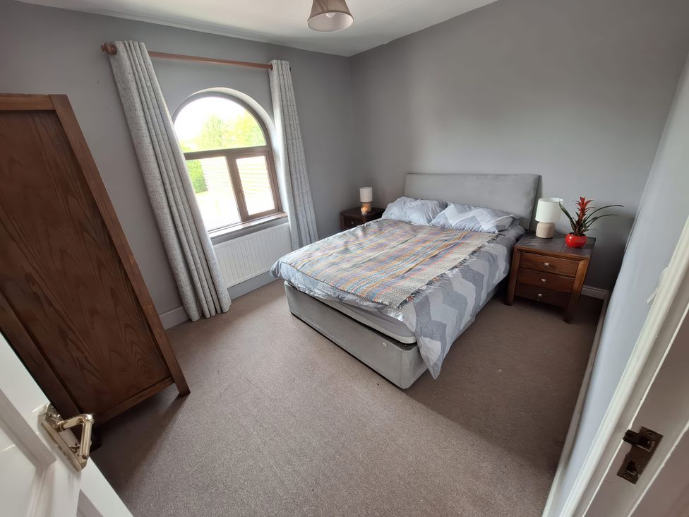 A bedroom with a bed and bedside tables at Lilly's Bungalow in Timoleague