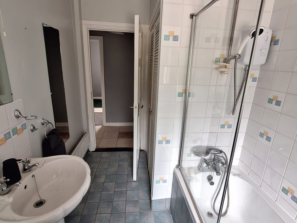 A bathroom with a sink and shower at Lilly's Bungalow in Timoleague
