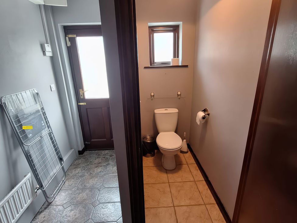 A bathroom featuring a toilet and sink at Lilly's Bungalow in Timoleague