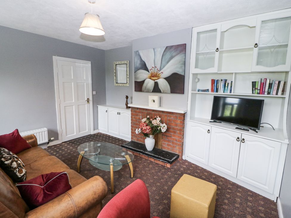 A living room with a sofa and television at Lilly's Bungalow in Clonakilty, County Cork