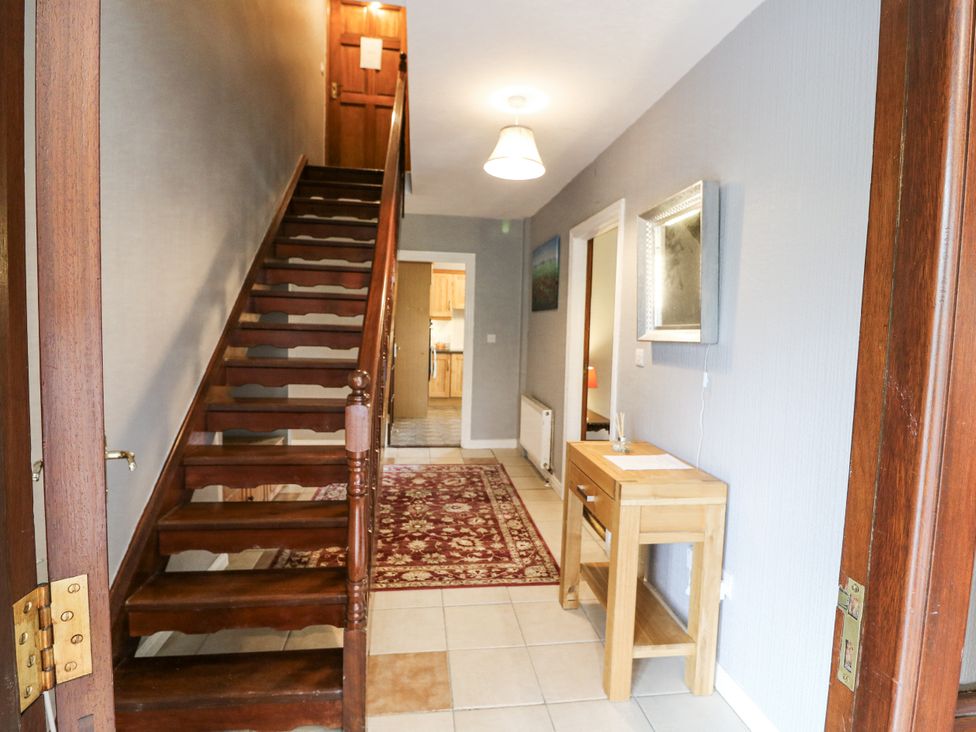 A hallway with a staircase and console table at Lilly's Bungalow in Clonakilty, County Cork