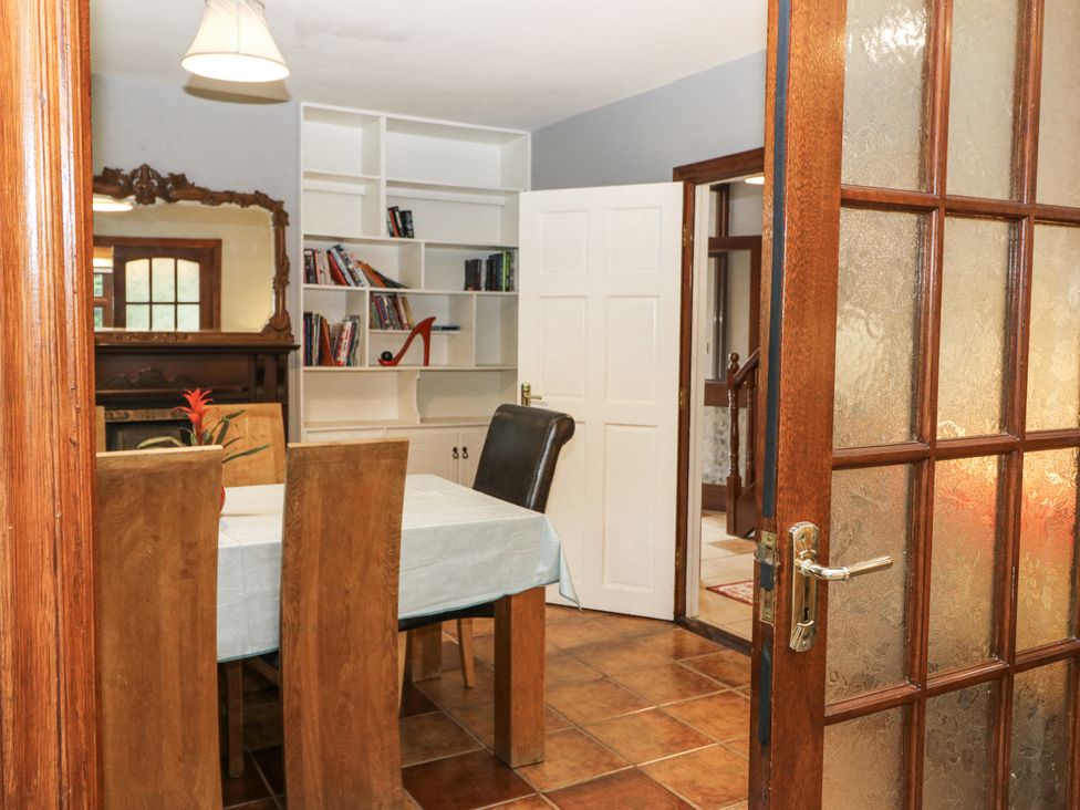 A dining room with a table and bookshelf at Lilly's Bungalow in Clonakilty, County Cork