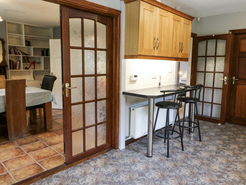 A kitchen with bar stools and a table at Lilly's Bungalow in Clonakilty, County Cork