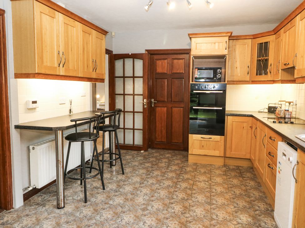 A kitchen with wooden cabinets and a countertop at Lilly's Bungalow in Clonakilty, County Cork
