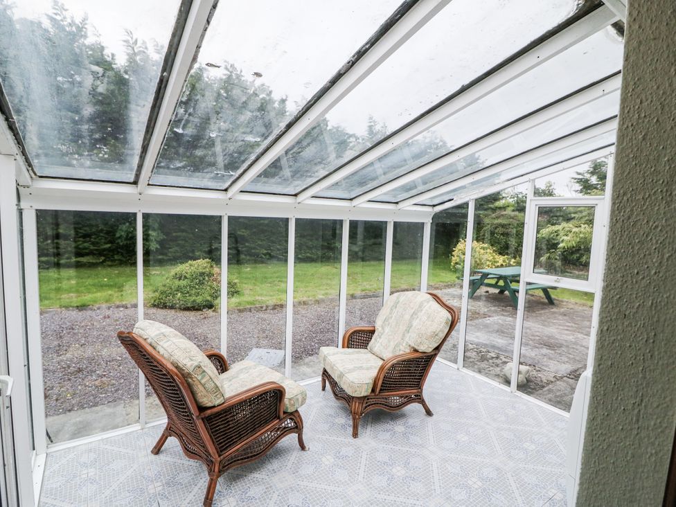 A conservatory with two chairs and a table at Lilly's Bungalow in Clonakilty, County Cork