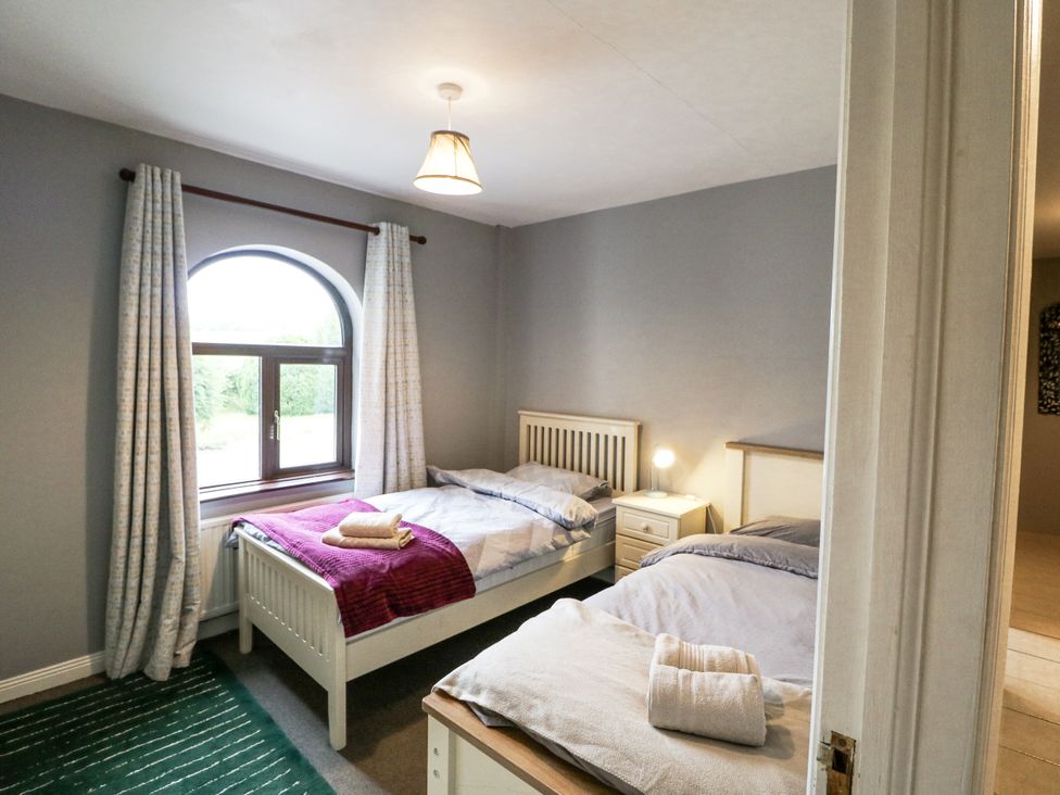 A bedroom with two beds and a window at Lilly's Bungalow in Clonakilty, County Cork