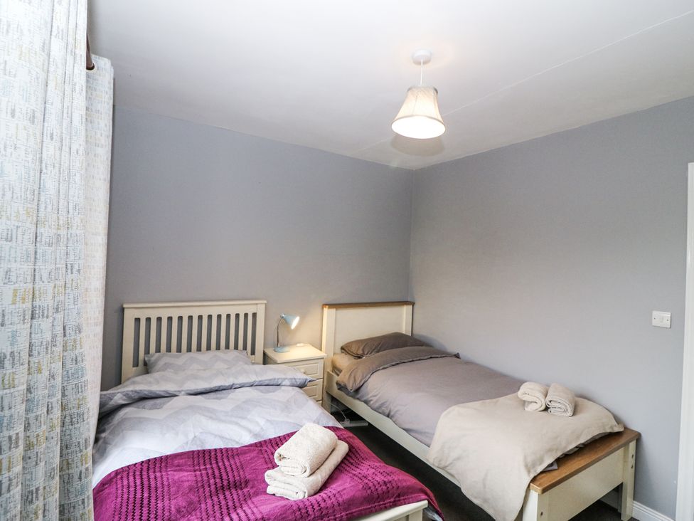 A bedroom with two beds and linens at Lilly's Bungalow in Clonakilty, County Cork