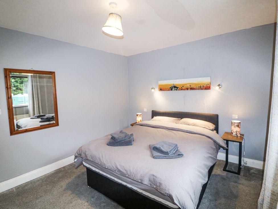 A bedroom with a bed and a mirror at Lilly's Bungalow Clonakilty County Cork