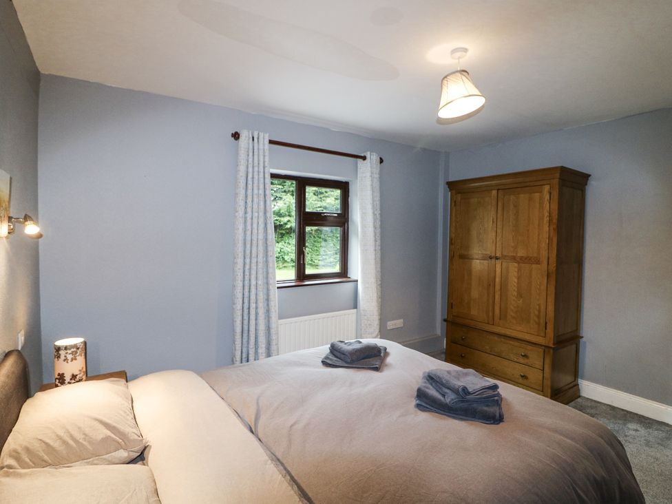A bedroom with a bed and wardrobe at Lilly's Bungalow Clonakilty, County Cork