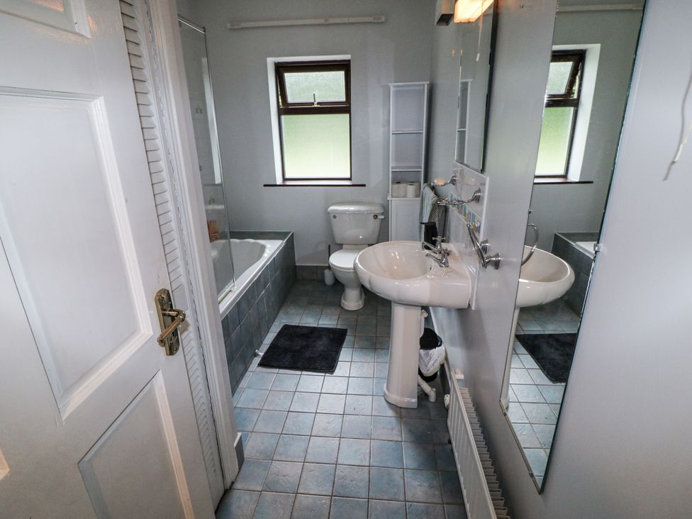 A bathroom with a bathtub, sink, and toilet at Lilly's Bungalow, Clonakilty, County Cork