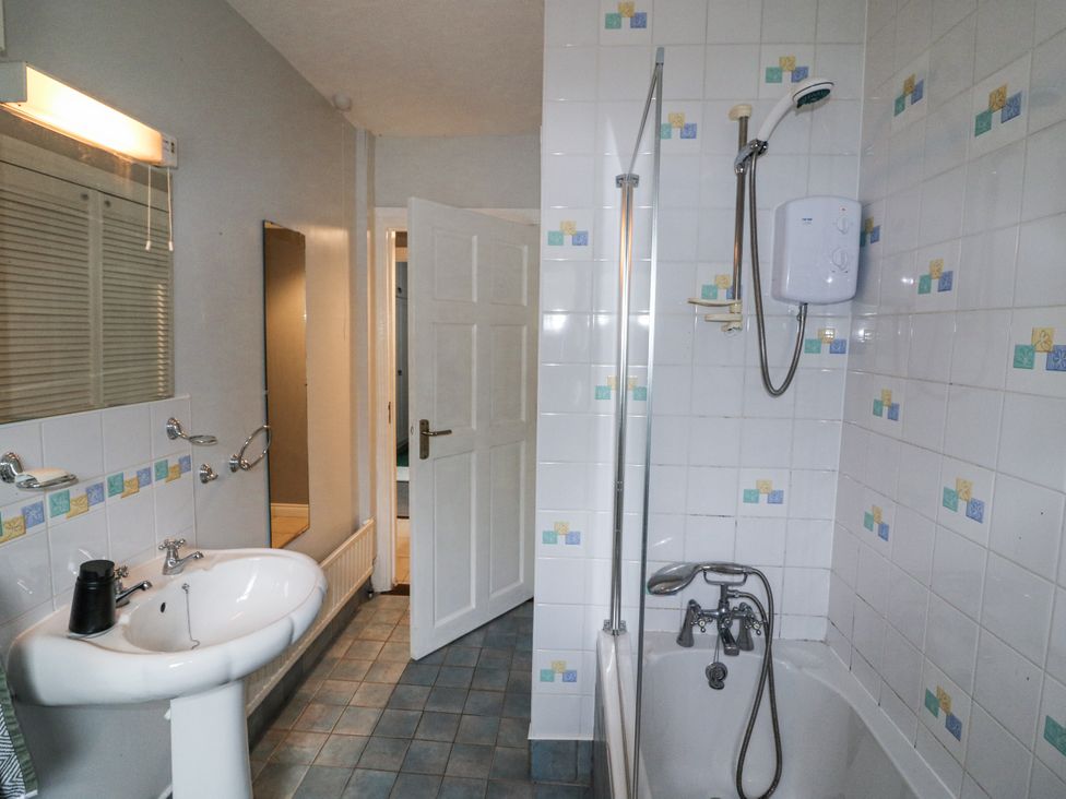 A bathroom with a sink, shower, and tub at Lilly's Bungalow in Clonakilty, County Cork
