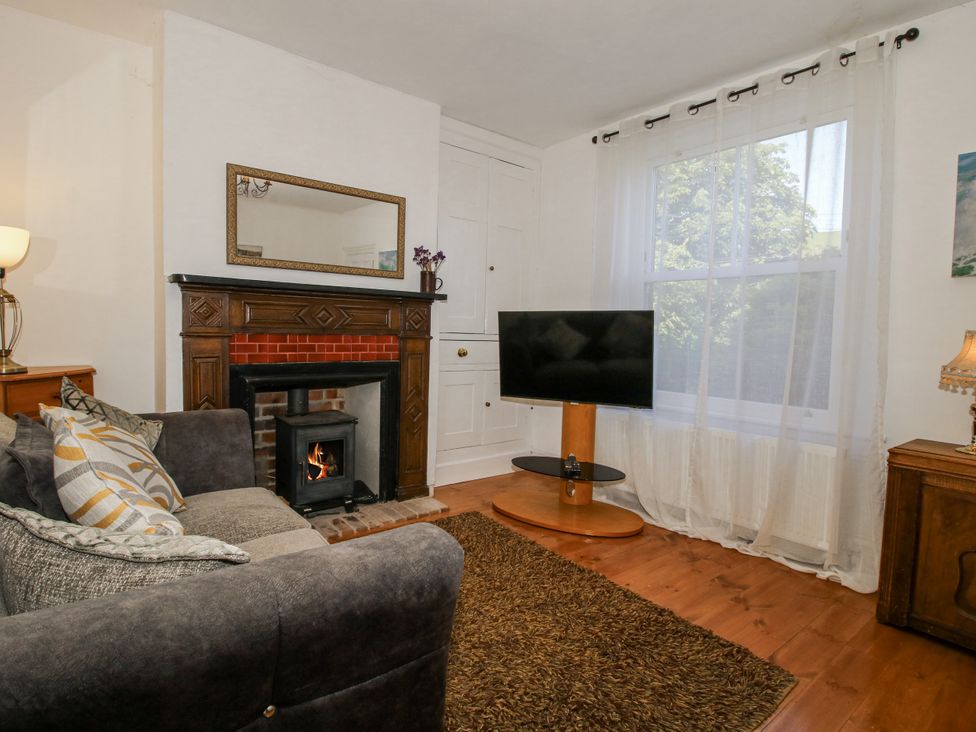 A living room with a sofa and fireplace at 157 Watling Street South in Church Stretton