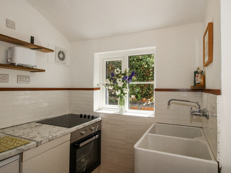 A kitchen with a sink, oven, and flower vase at 157 Watling Street South in Church Stretton