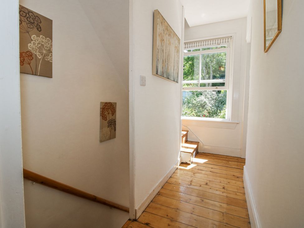A hallway with a staircase and paintings at 157 Watling Street South Church Stretton