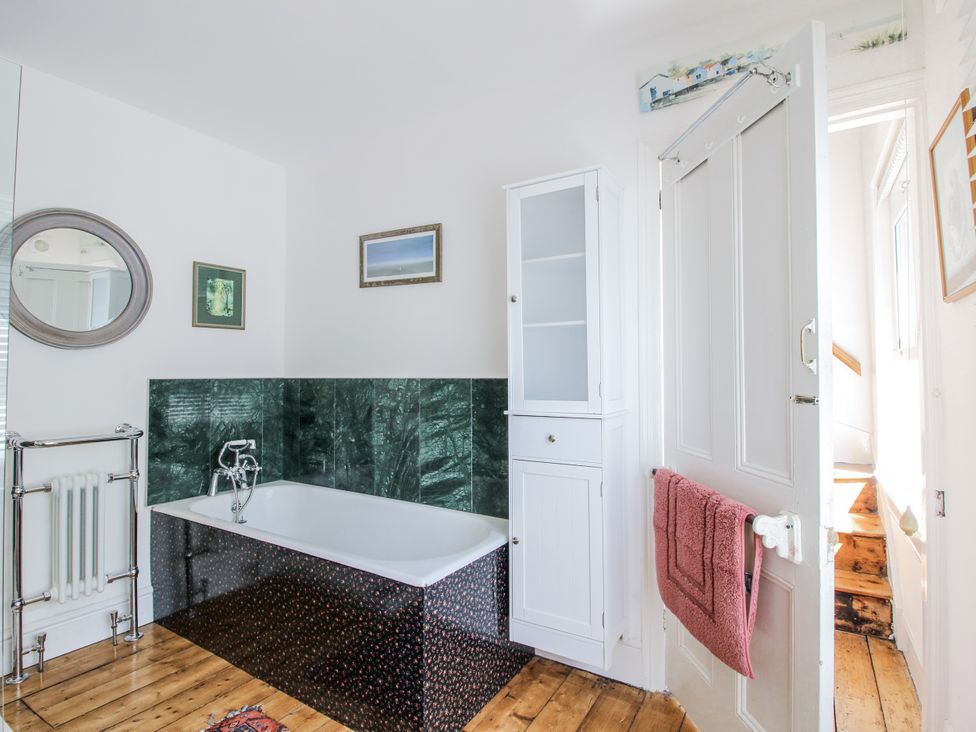 A bathroom with a bathtub and a cabinet at 157 Watling Street South Church Stretton