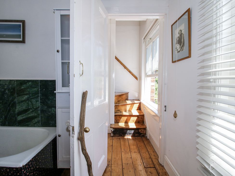 A bathroom with a bathtub and stairs leading to another level at 157 Watling Street South Church Stretton
