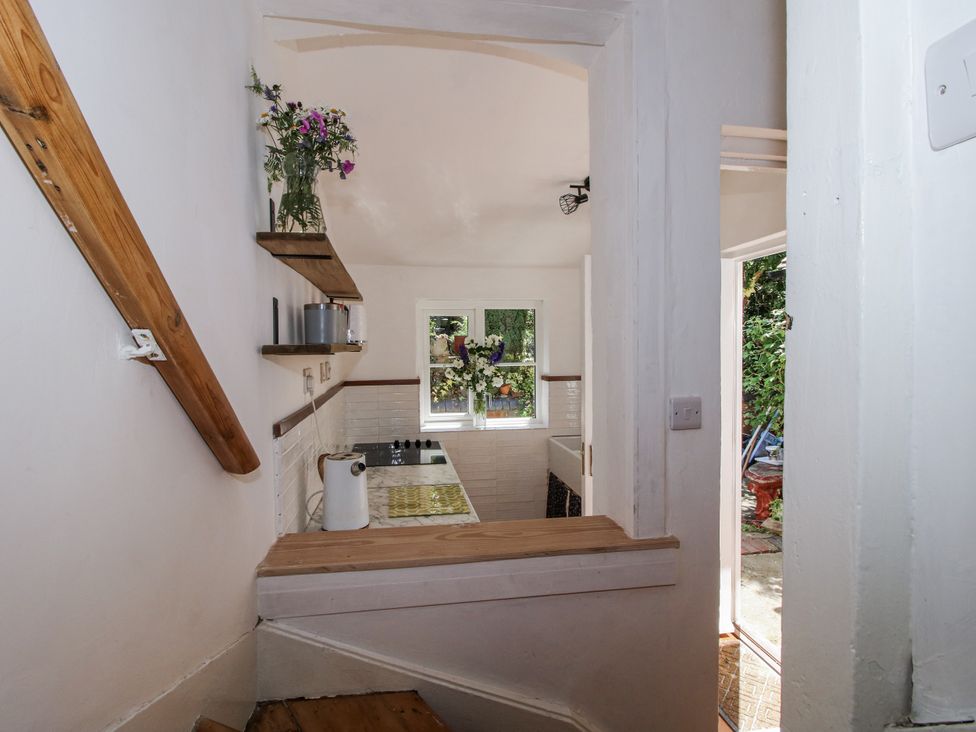 A view of a kitchen with stairs and a window at 157 Watling Street South in Church Stretton