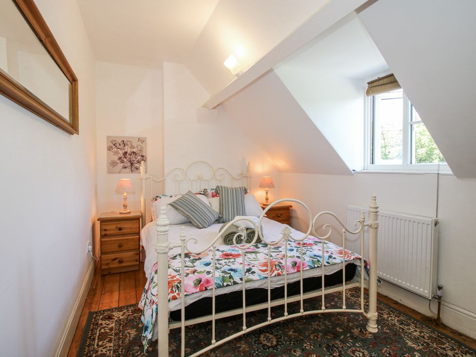 A bedroom with a bed and nightstand at 157 Watling Street South in Church Stretton