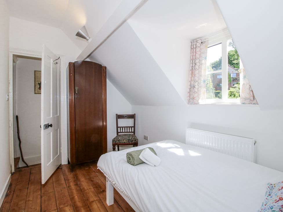 A bedroom with a bed and a wardrobe at 157 Watling Street South Church Stretton