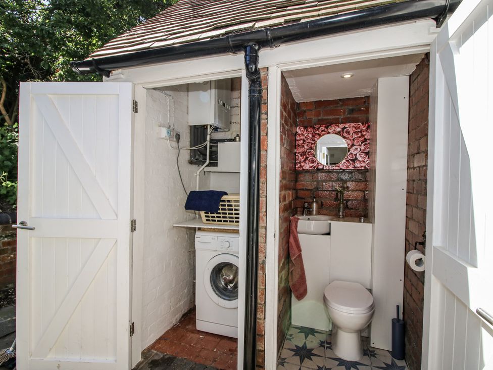 A bathroom with a washing machine and toilet at 157 Watling Street South Church Stretton