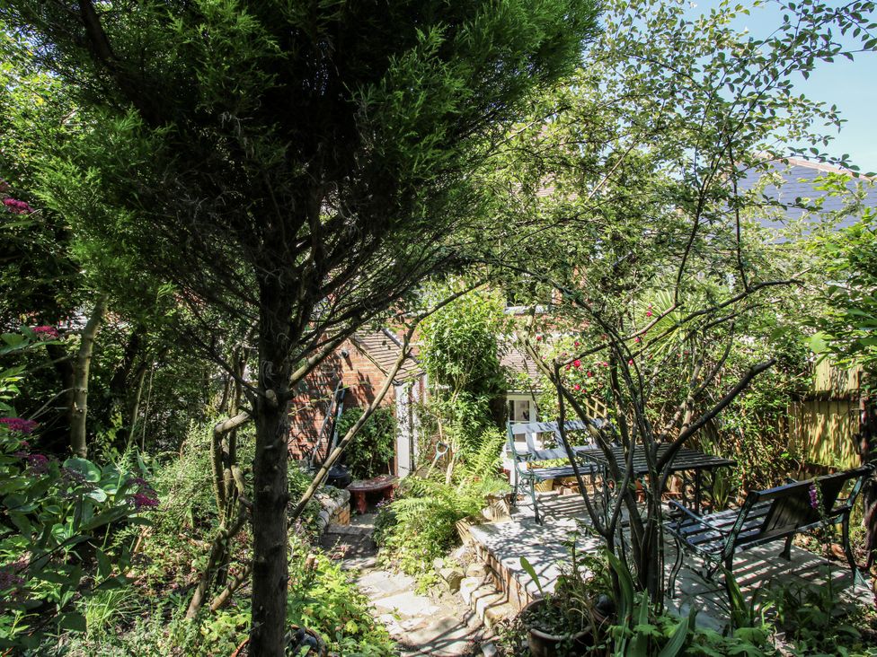 A garden with a pathway and seating area at 157 Watling Street South, Church Stretton