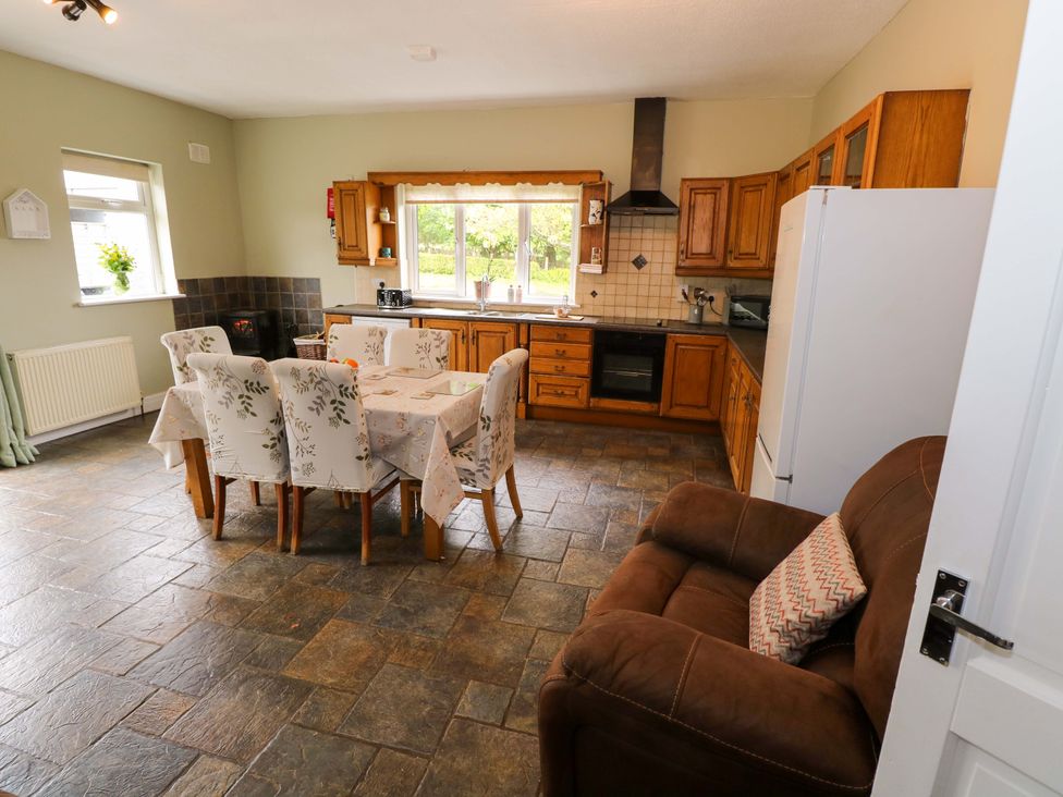 A kitchen with a dining table and chairs and a refrigerator at CARROWREAGH