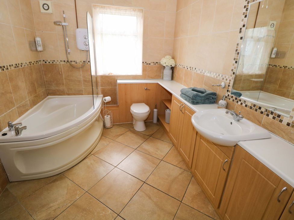 A bathroom with a bathtub, toilet, and sink at CARROWREAGH