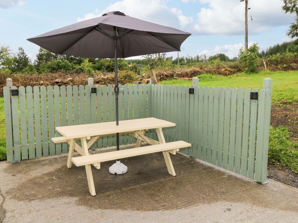 An outdoor seating area with a table and umbrella at CARROWREAGH