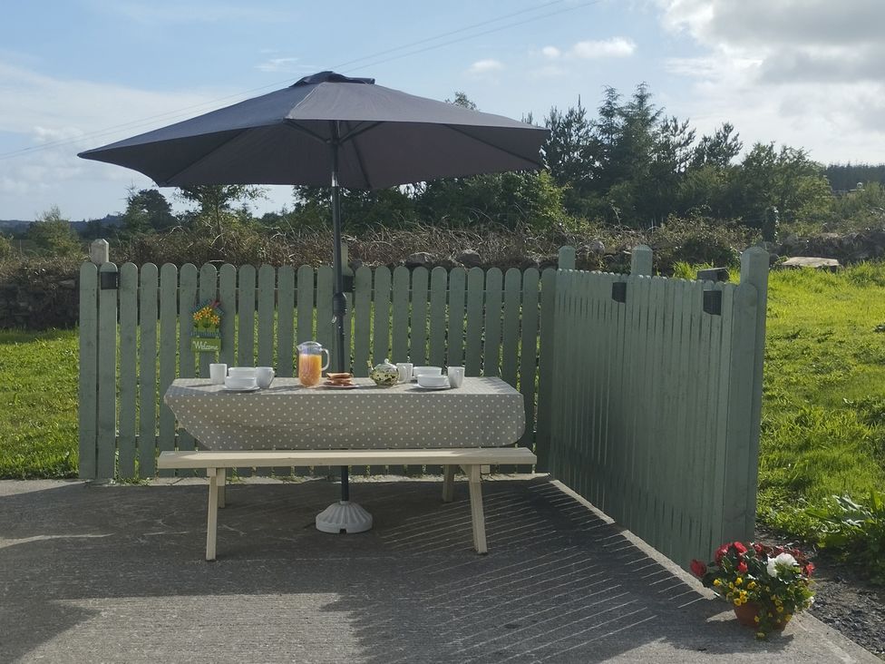 An outdoor seating area with a table and umbrella at Carrowreagh, Aclare, County Sligo