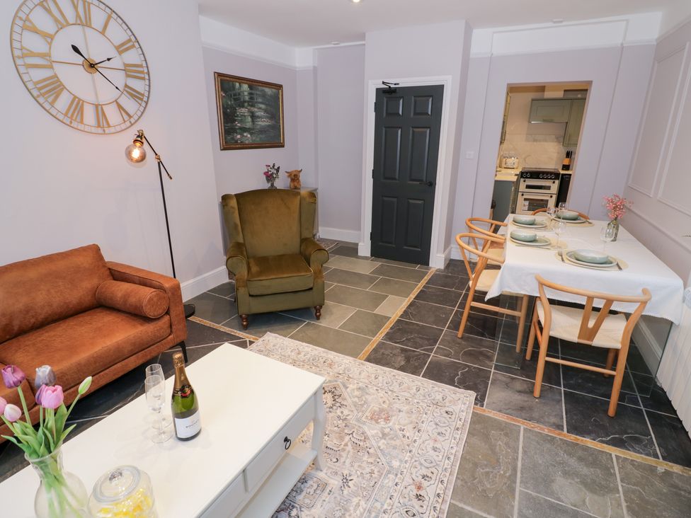 A living room with furniture and kitchen access at 12 Montpellier Arcade Cheltenham