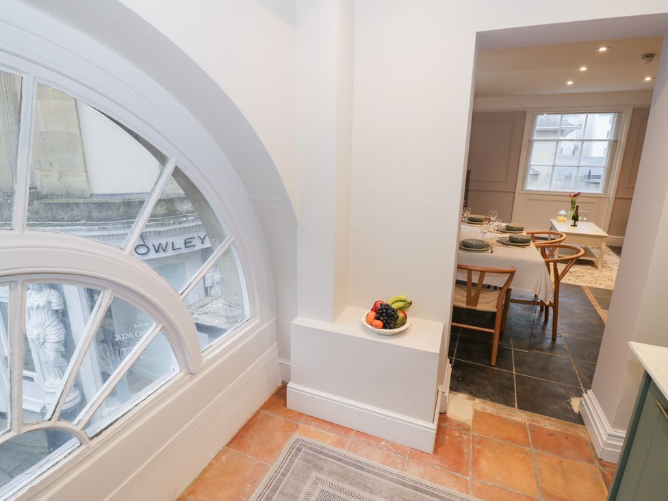 A kitchen with a dining area viewed through a rounded window at 12 Montpellier Arcade Cheltenham