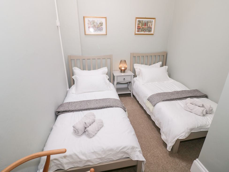 A bedroom with two single beds and a nightstand at 12 Montpellier Arcade Cheltenham