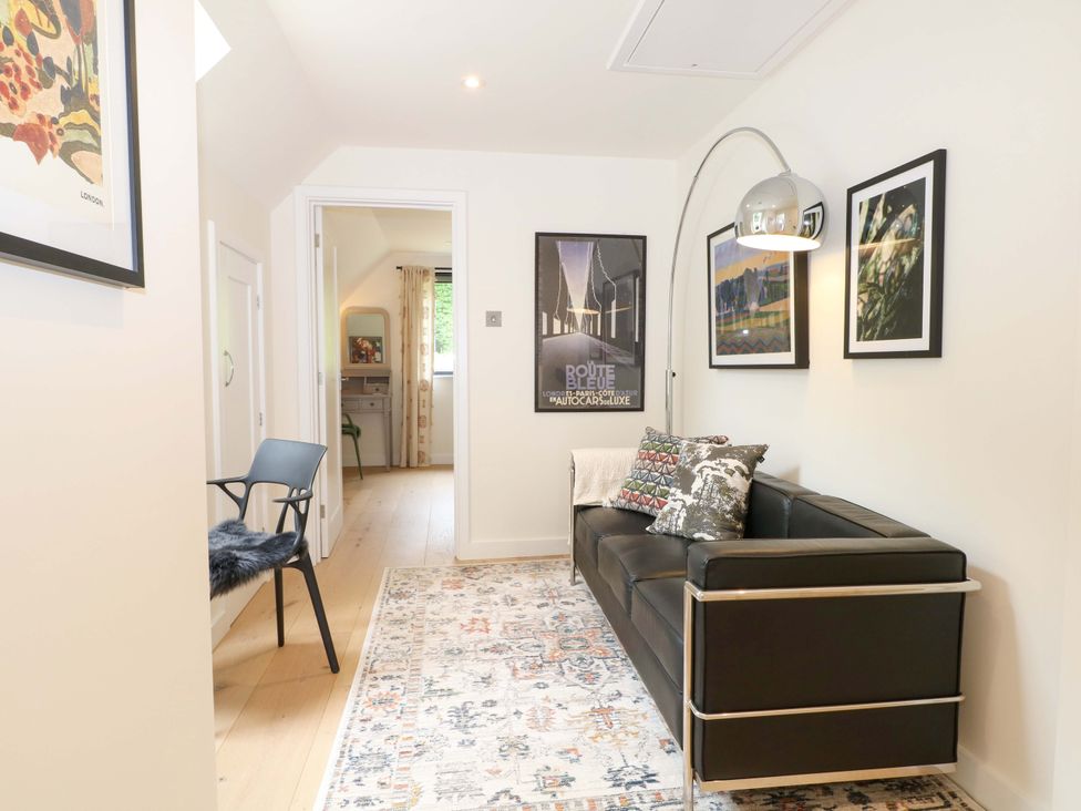 A living room with a sofa and wall art at Lakeside Lodge in Witherenden Hill near Burwash