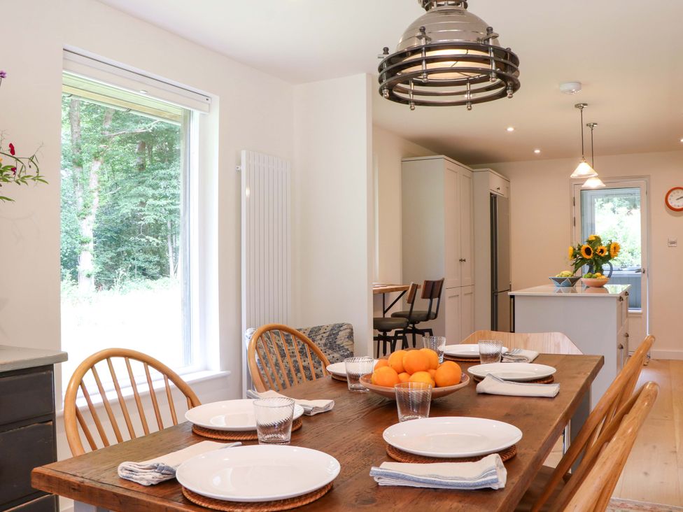 A kitchen with a dining table and chairs at Lakeside Lodge Witherenden Hill near Burwash