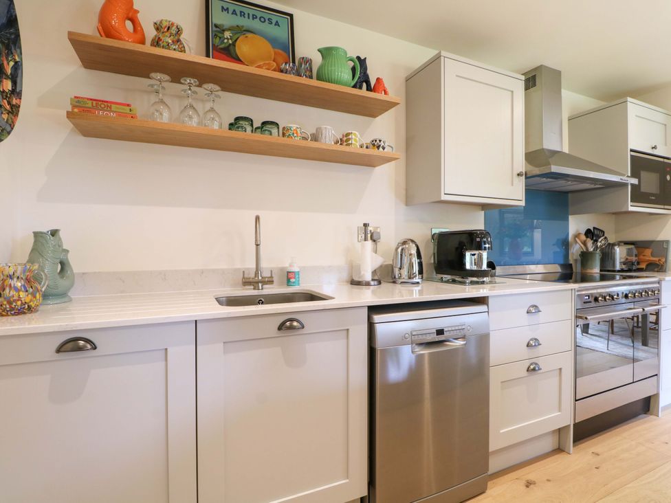 A kitchen with cabinets, sink, and appliances at Lakeside Lodge in Witherenden Hill near Burwash
