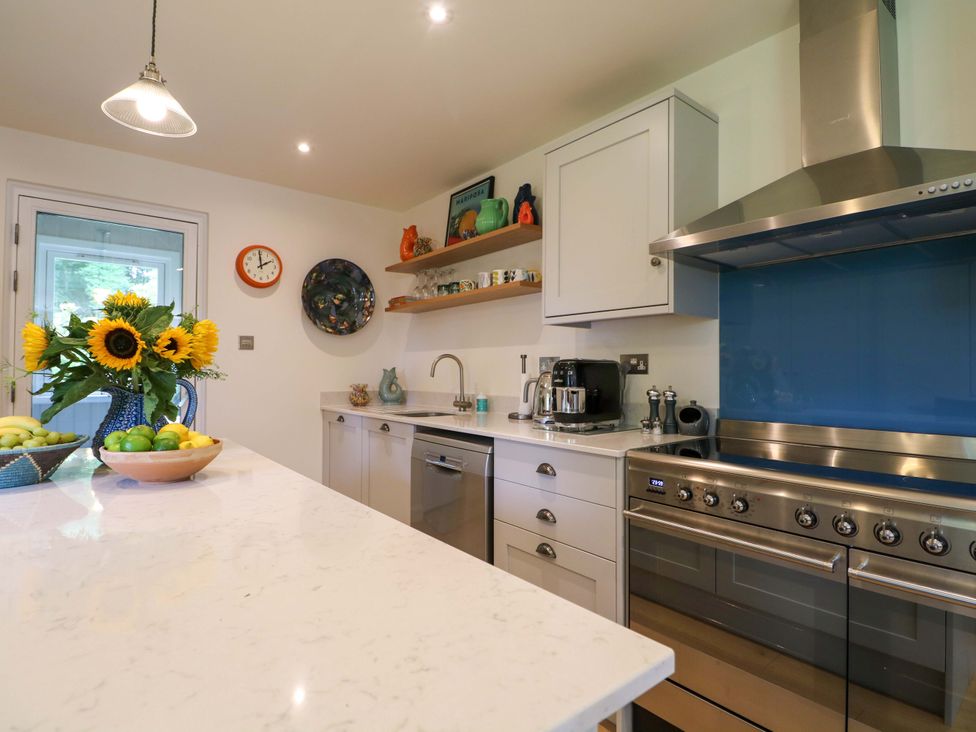 A kitchen featuring a sink, stove, and fridge at Lakeside Lodge near Witherenden Hill