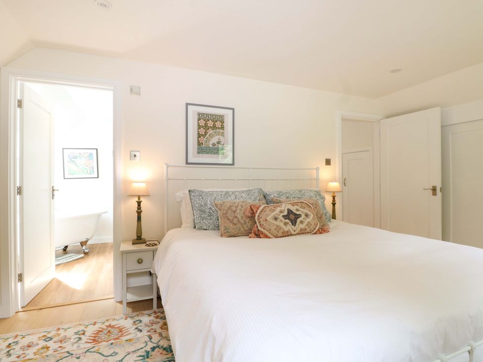 A bedroom with a bed and artwork at Lakeside Lodge in Witherenden Hill near Burwash