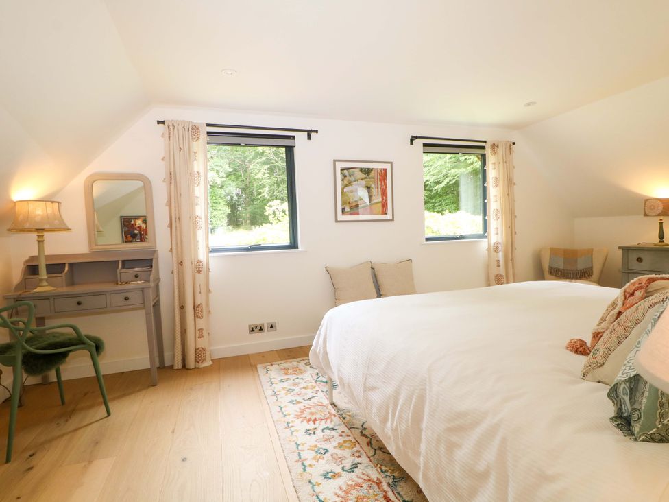 A bedroom with a bed and desk at Lakeside Lodge in Witherenden Hill near Burwash