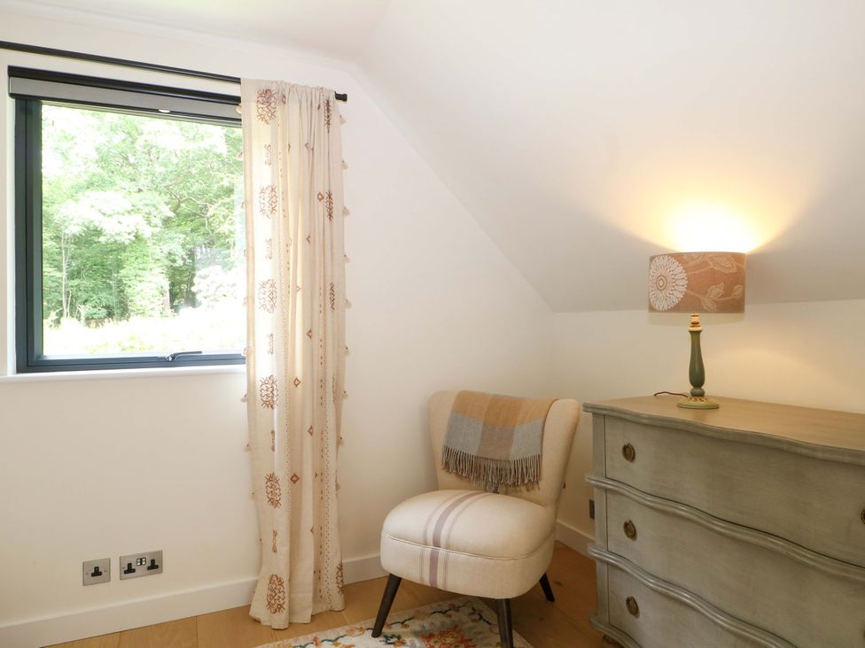 A bedroom with furniture and a window at Lakeside Lodge Witherenden Hill near Burwash