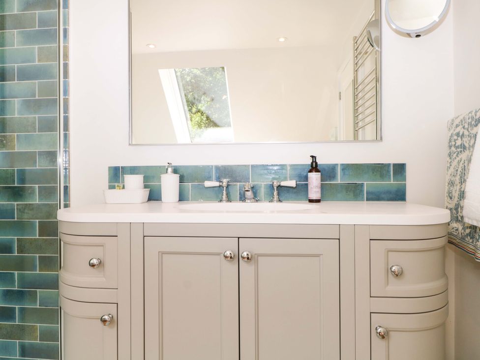 A bathroom with a sink and mirror at Lakeside Lodge in Witherenden Hill near Burwash