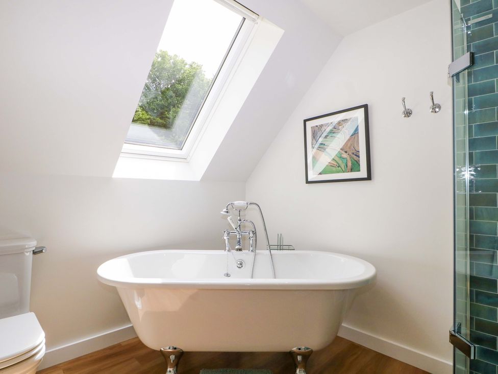 A bathroom with a bathtub and toilet at Lakeside Lodge near Witherenden Hill