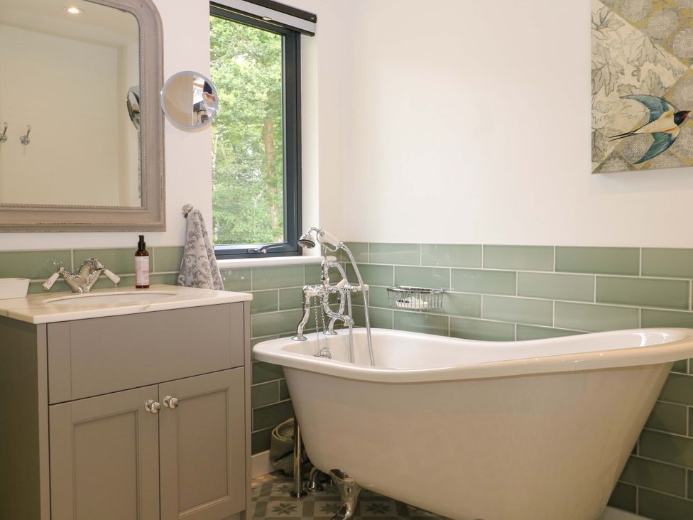 A bathroom with a bathtub and sink at Lakeside Lodge near Witherenden Hill Burwash