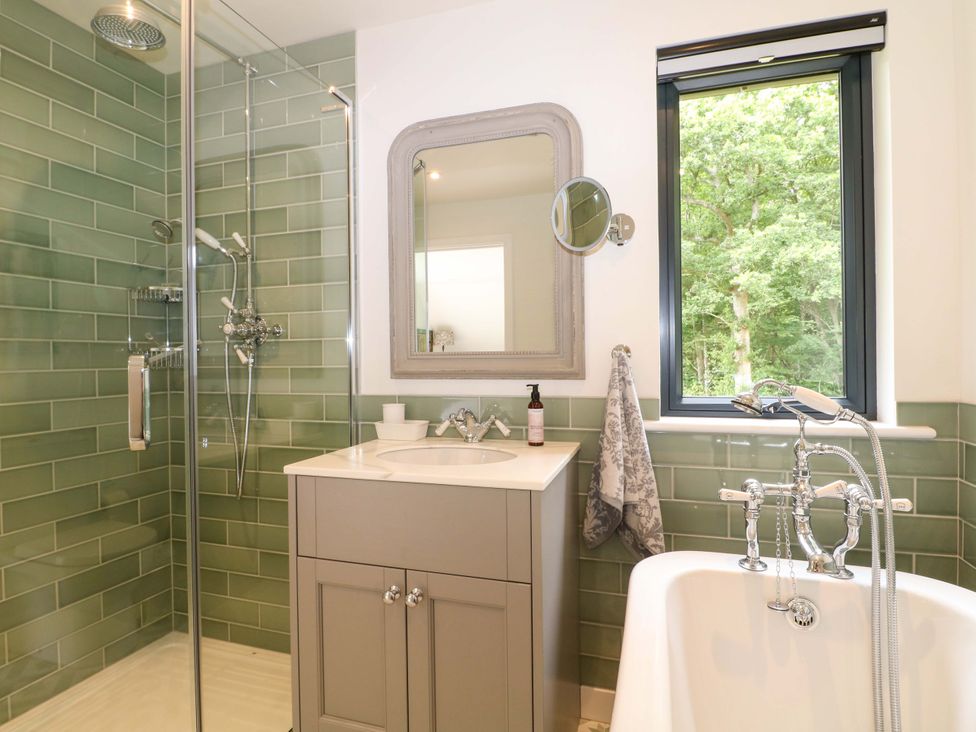 A bathroom with a shower, bathtub, and sink at Lakeside Lodge near Witherenden Hill Burwash