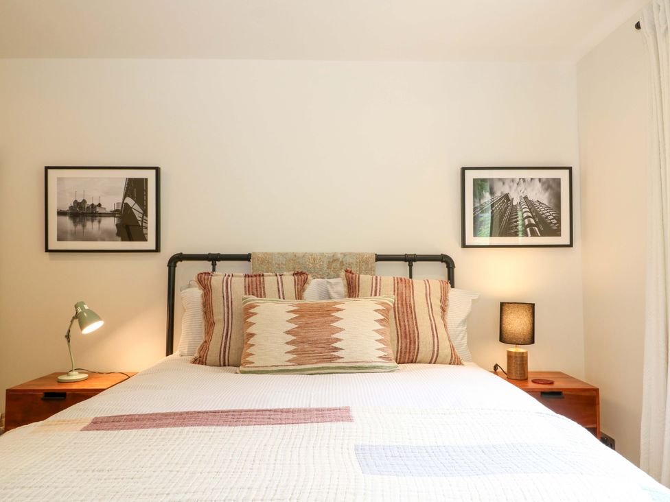 A bedroom with a bed and bedside lamps at Lakeside Lodge, Witherenden Hill near Burwash