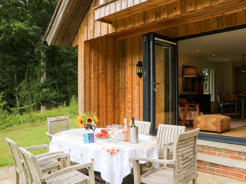 An outdoor dining area with a table and chairs at Lakeside Lodge witherenden Hill near Burwash