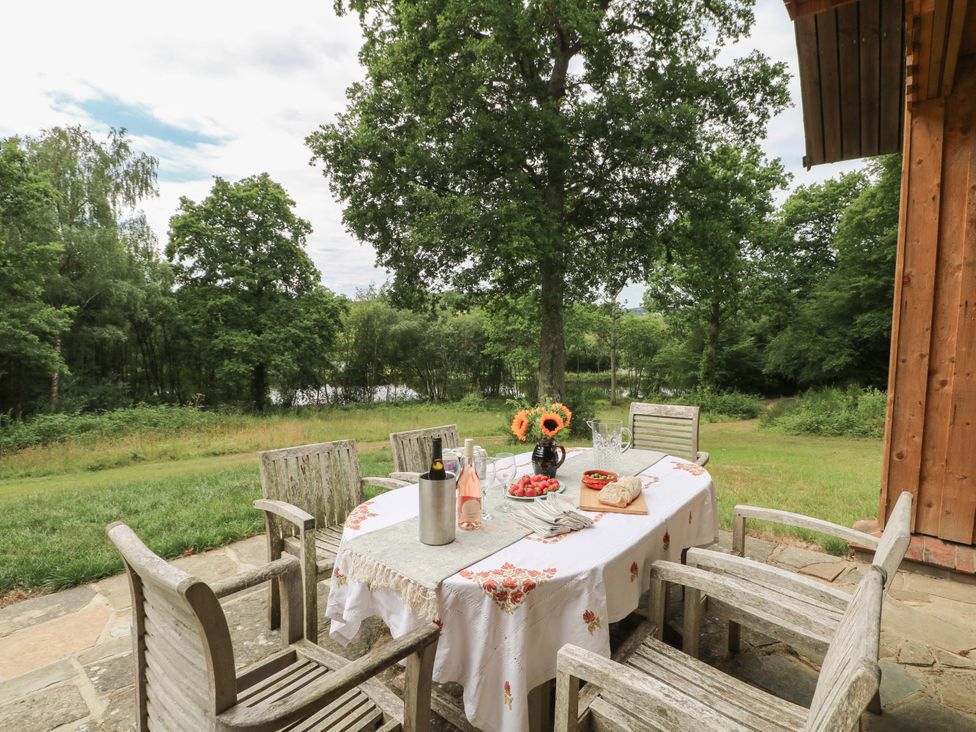 An outdoor dining area with a table and chairs at Lakeside Lodge Witherenden Hill near Burwash