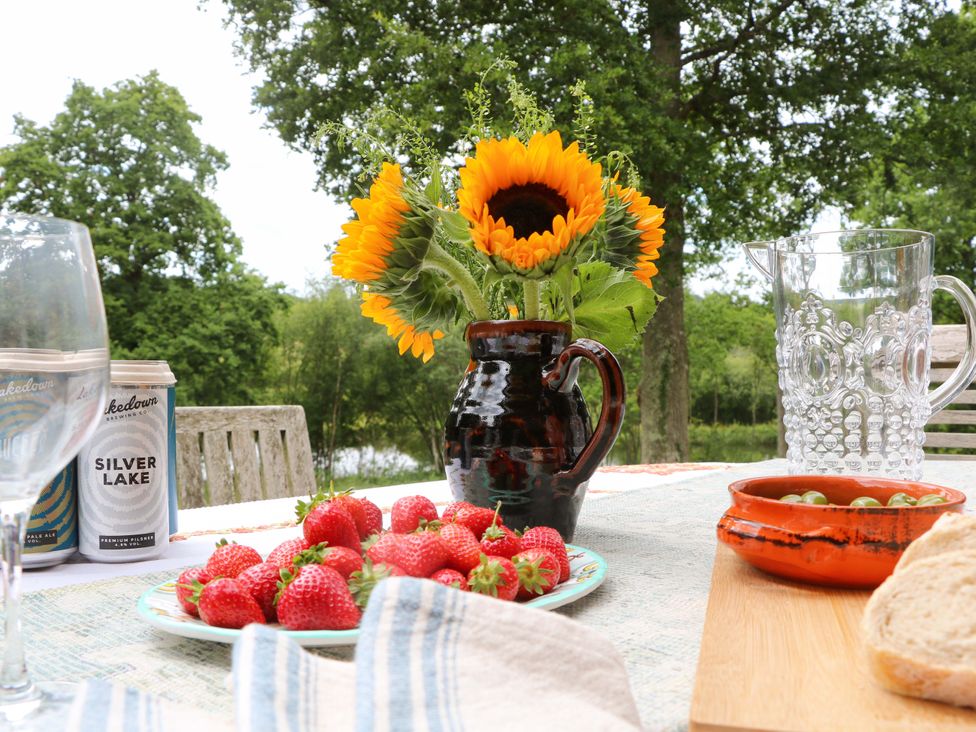 An outdoor dining setup with strawberries and a sunflower at Lakeside Lodge near Witherenden Hill Burwash