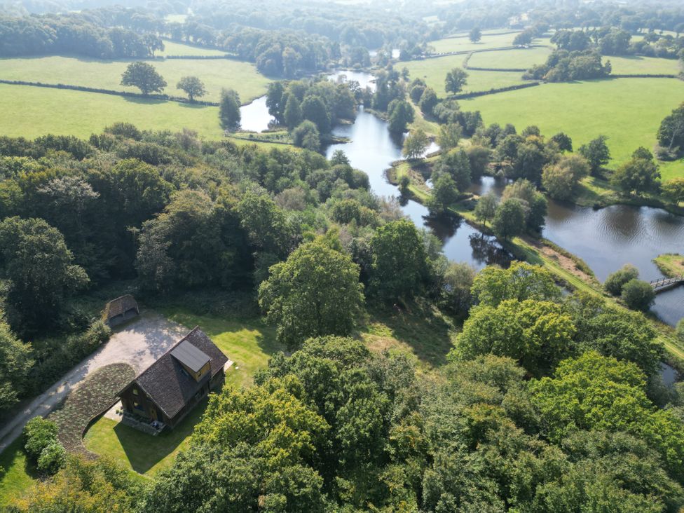 An aerial view of a house near a lake at Lakeside Lodge in Witherenden Hill near Burwash